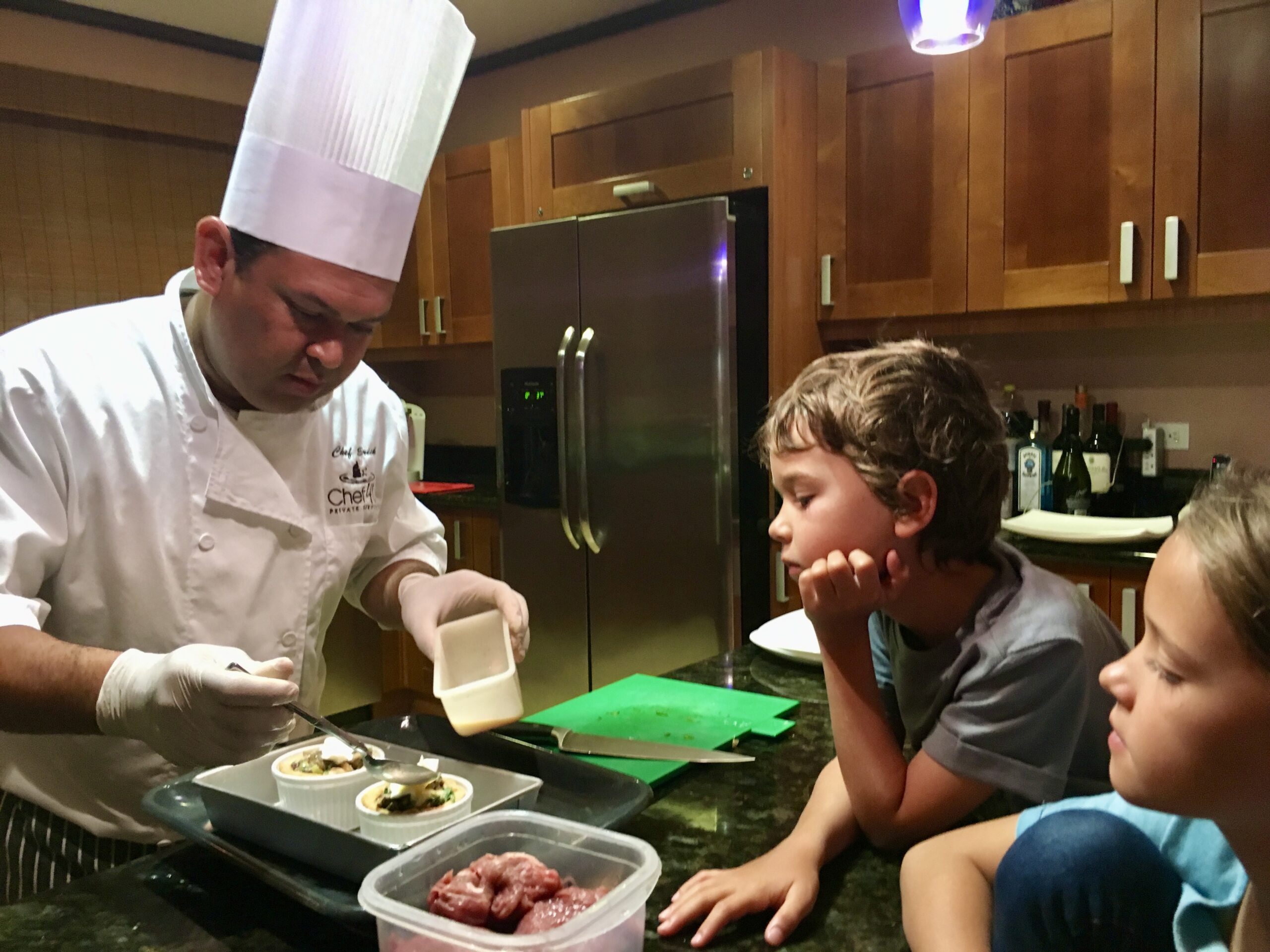 Private chef preparing appetizers while children watch in a luxury villa in Peninsula Papagayo