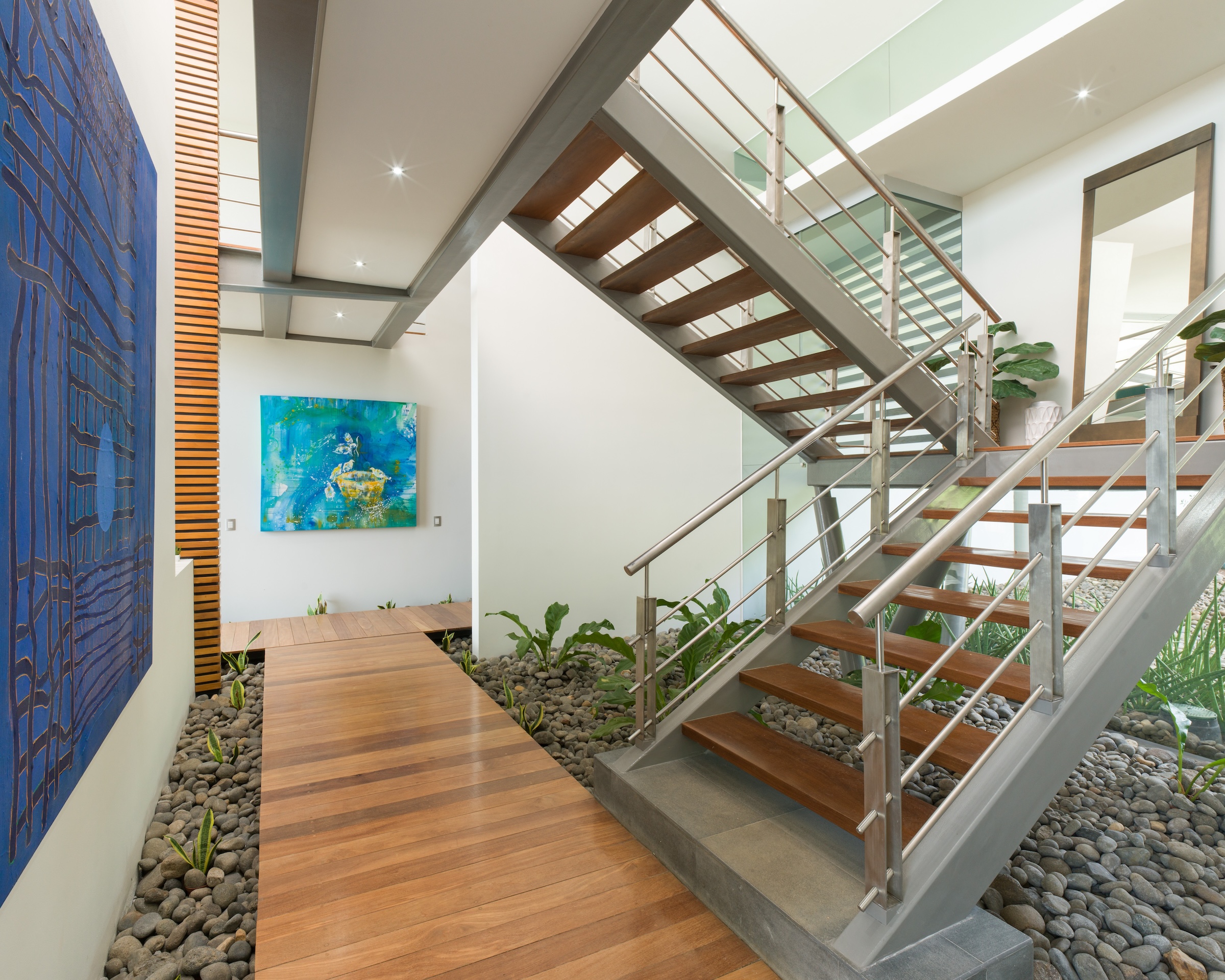 Contemporary interior architecture with wood walkway, tropical landscaping and modern design at Sky’s Edge